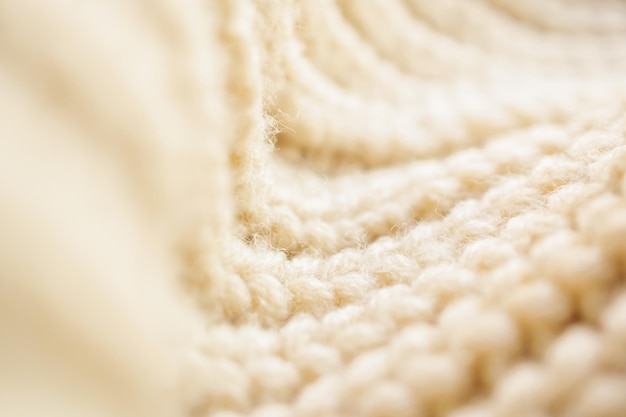 Closeup beige knitted woolen fabric texture background