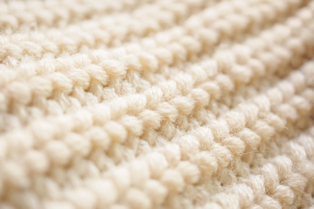 Closeup beige knitted woolen fabric texture background