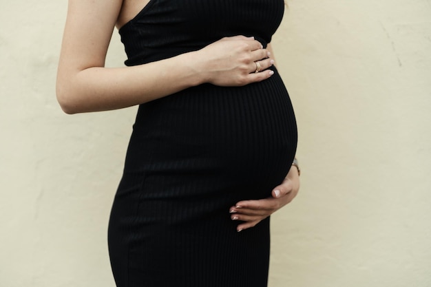 Photo closeup of the belly of a pregnant woman husband's hands touch the belly of his pregnant wife beautiful pregnancy