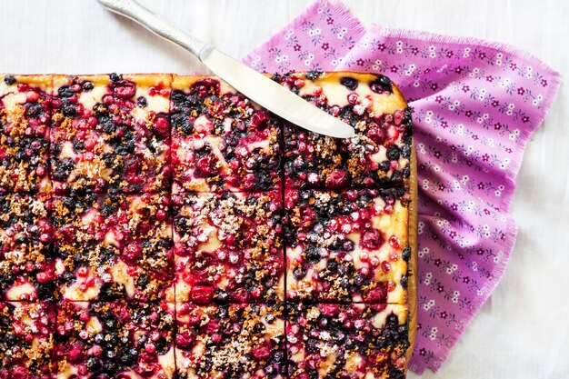 Closeup of berry pie with cottage cheese cut on square slices