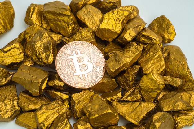 Primo piano di valuta digitale bitcoin e pepita d'oro