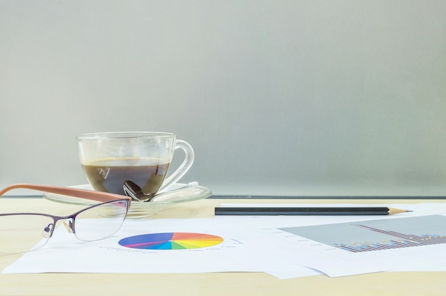 Closeup black coffee with work paper on wooden desk