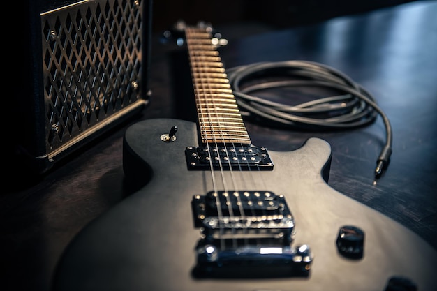 Photo closeup black electric guitar on a dark background