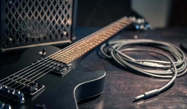 Closeup black electric guitar on a dark background