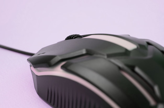 Photo closeup of a black gaming optical mouse on a pink