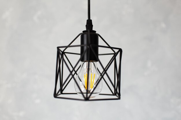 Closeup of black hanging lamp on grey background