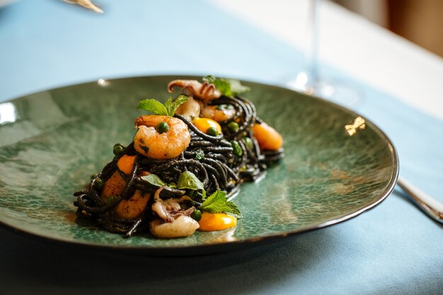 Closeup on black spaghetti with seafood and saffron sauce