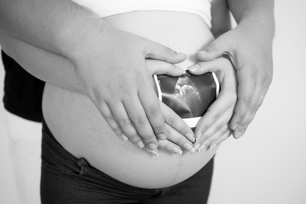 Foto concettuale in bianco e nero del primo piano di giovane coppia che prevede baby