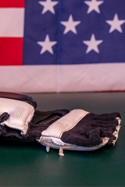 Photo closeup of black and white mma or boxing gloves with an american flag in the background