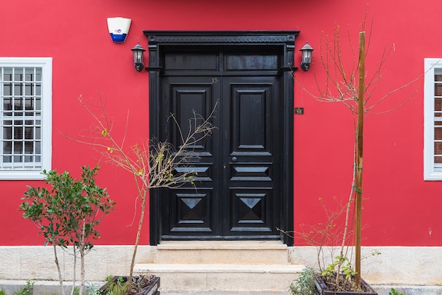 Closeup of a  black wooden door in an old stone  red mansion house