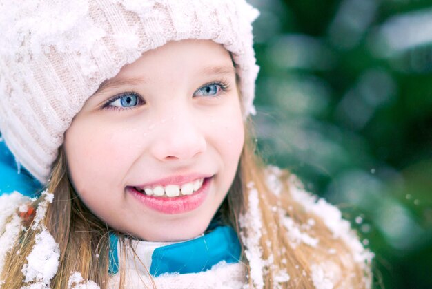 A closeup of a blue eyed girl in winter hat