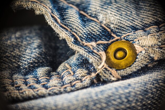 Closeup on blue jeans stitching and button