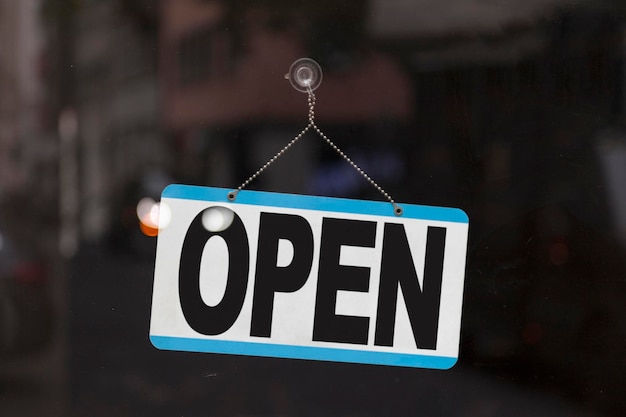 Photo closeup on a blue open sign in the window of a shop displaying the message openxa