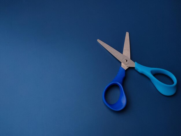 Photo closeup blue scissors on a blue background