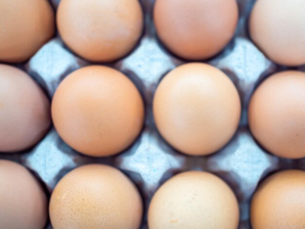 Closeup blurred top view of raw chicken eggs background