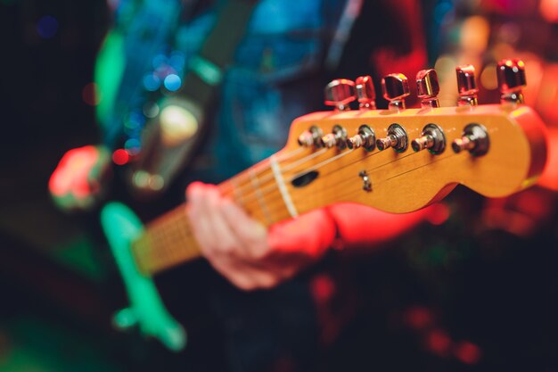 Primo piano delle mani maschili sfocate suonare la chitarra.