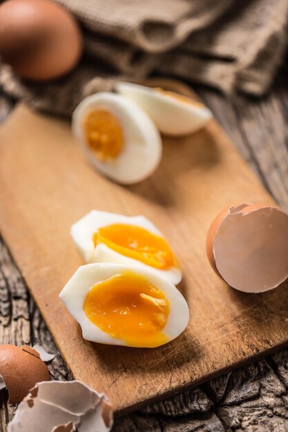 Closeup boiled or raw chicken eggs on wooden board