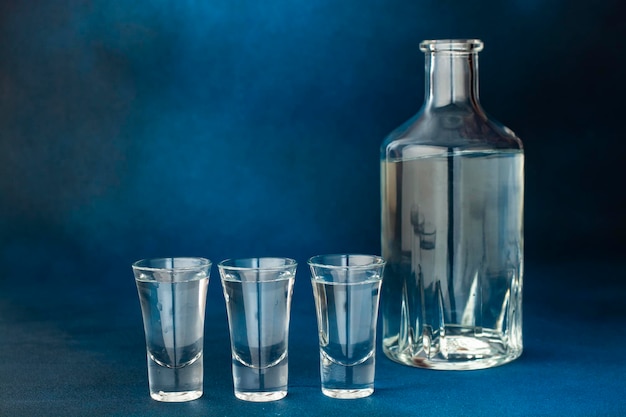 closeup of a bottle of vodka and three glasses