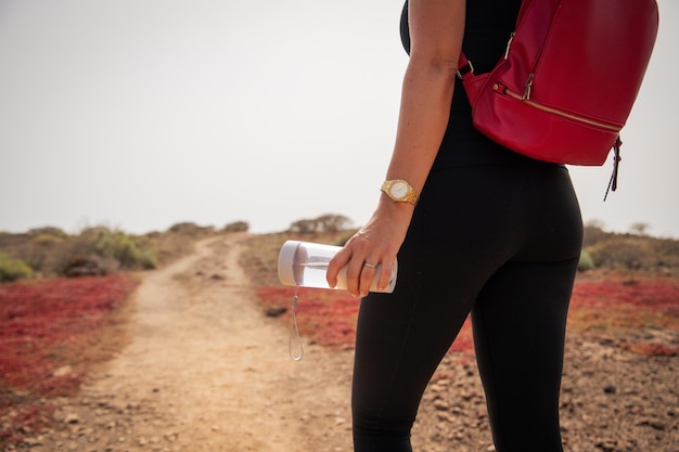 Closeup of a bottle of water held by a female hiker during a hike hydration concept