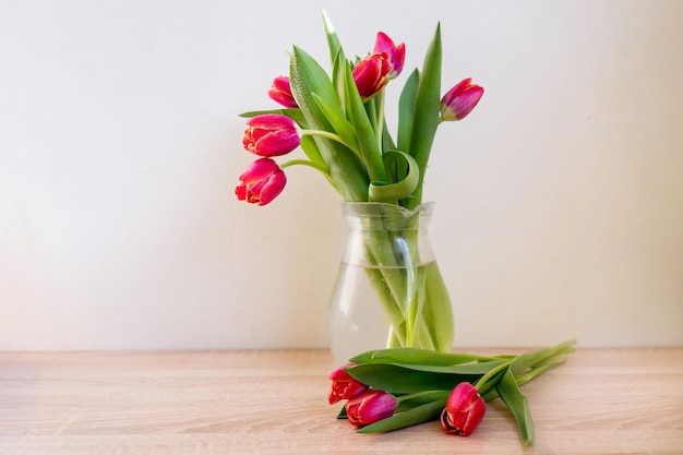 Primo piano di un bouquet di tulipani rosa in un vaso su uno sfondo bianco sulla felicità del tavolo di marmo