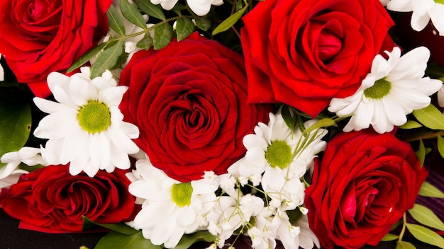 Closeup bouquet of red roses with with daisies