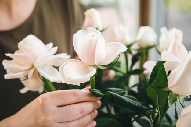 Primo piano un mazzo di rose nelle mani di un fiorista femminile