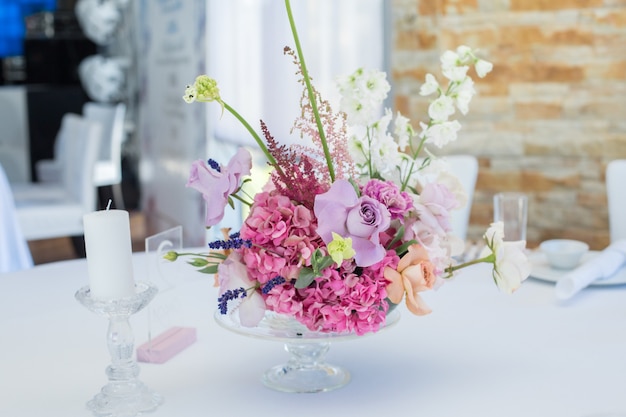 Closeup bouquet set of fresh roses, astilbe, carnation, delphinium, eustoma, ornithogalum, lavender and hydrangea on wedding banquet