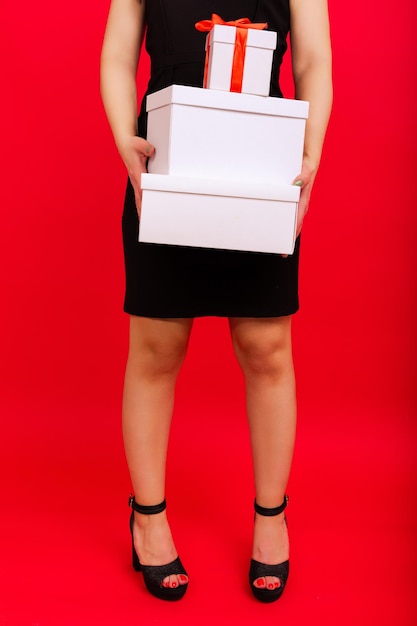 Closeup of a box in the hands of a woman on a red background Happy New Year Greetings