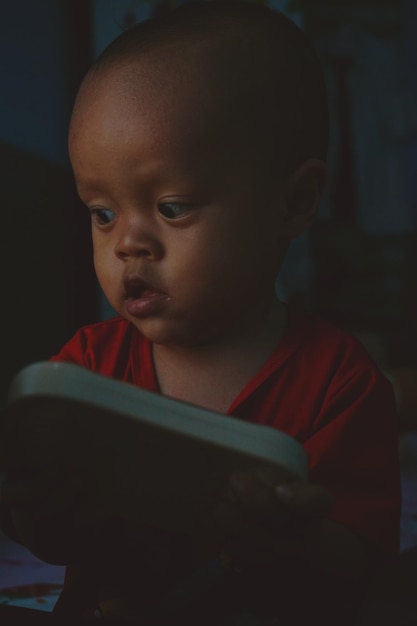 Photo closeup of boy holding toy in darkroom