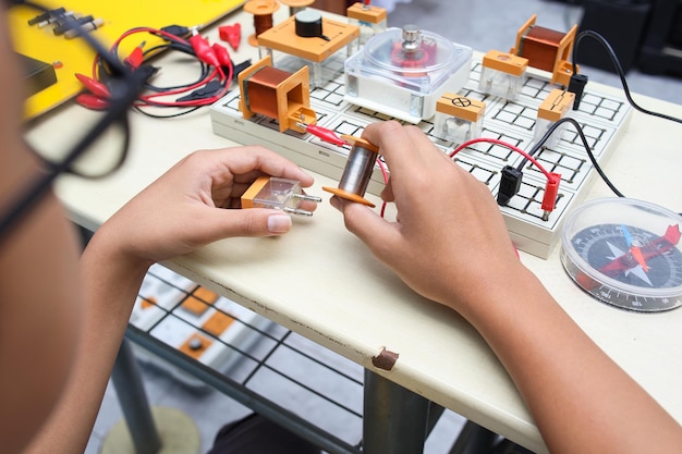 Closeup of boy working with circuits wires computer motor on his project Science Technology E