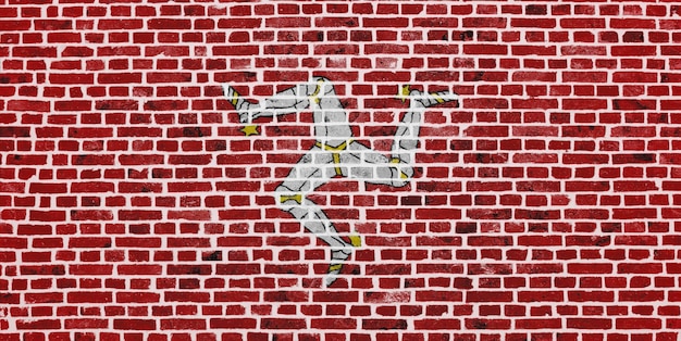 Closeup on a brick wall with the flag of the Isle of Mann painted on it