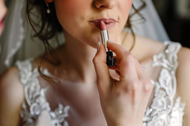 Closeup of bride applying her lipstick