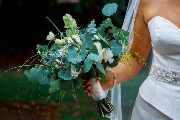 Photo closeup of bride hands holding beautiful wedding bouquet
