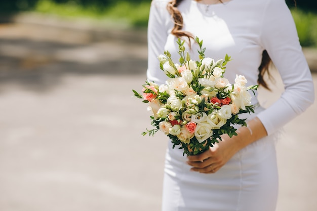 Foto primo piano della sposa che tiene il bellissimo bouquet da sposa