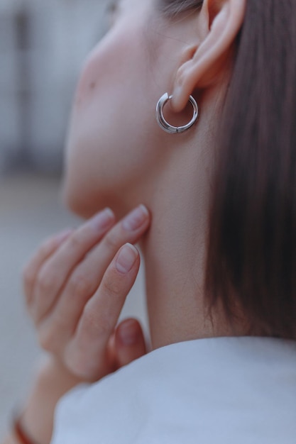 Closeup of bride in silver earring touching neck