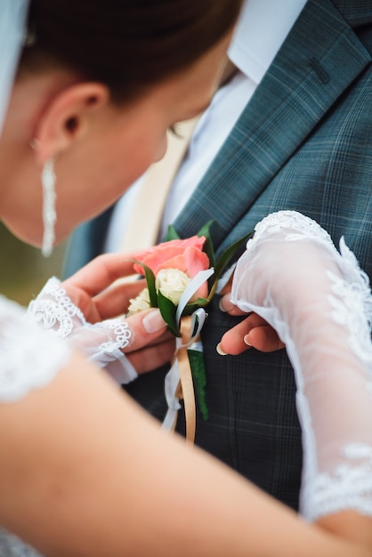 Closeup of a bride wearing a buttonhole on a groom