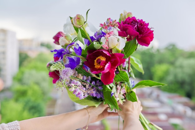 女性の手で花の明るい花束のクローズアップ