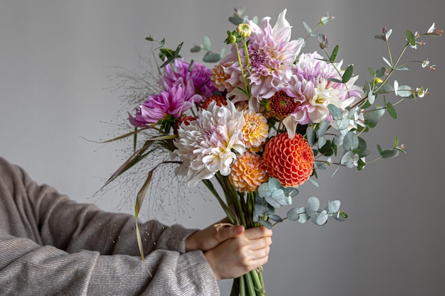 女性の手に菊と明るいお祭りの花束のクローズアップ