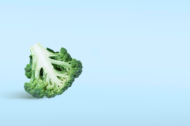 Closeup broccoli in tweeën gesneden omgekeerd op een blauwe achtergrond met een schaduw