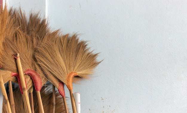 Closeup broom on white brick wall