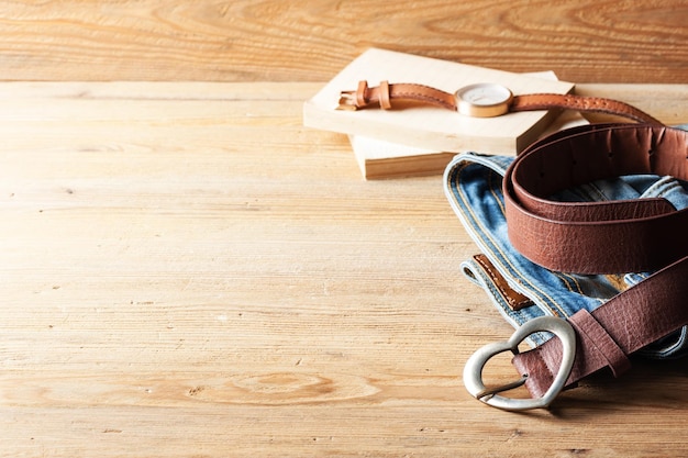 Closeup brown leather woman belt with metal heart shaped belt buckle on wooden board