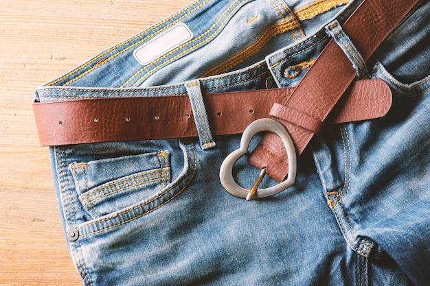 Closeup brown leather woman belt with metal heart shaped belt buckle