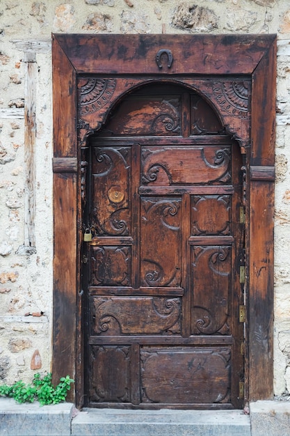 Closeup of a brown wooden door in an old stone mansion house