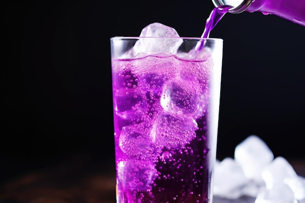 Closeup of bubbleridden grape soda pouring into a glass