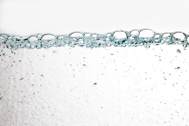 Primo piano bolle sott'acqua su sfondo bianco.