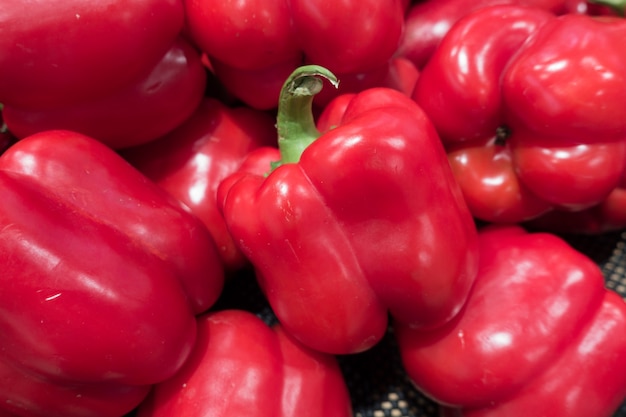 Closeup of bulk lot fresh red capsicums.