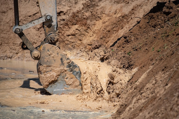 Closeup of bulldozer machine digging the ground and removing sand for excavation purpose