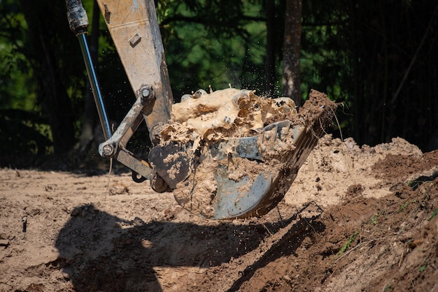 Foto primo piano della macchina del bulldozer che scava il terreno e rimuove la sabbia a scopo di scavo