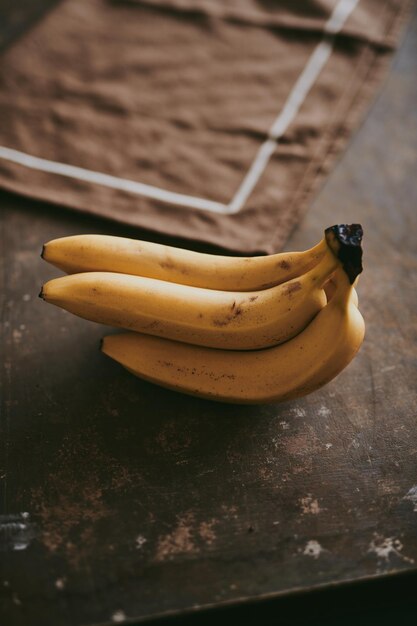 Foto close-up di un grappolo di banane su uno sfondo di texture marrone