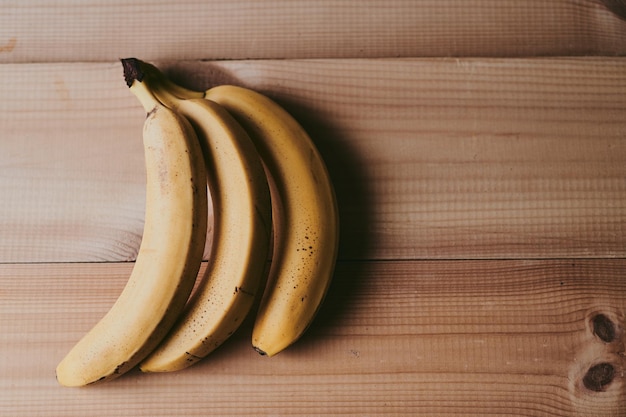 Closeup of a bunch of bananas on a wooden kitchen table background